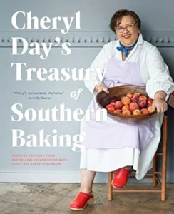 A cookbook cover featuring Cheryl Day, wearing a white apron and holding a wooden bowl