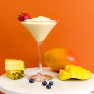 Creamy fruit dip in a martini glass with fresh fruit garnish.