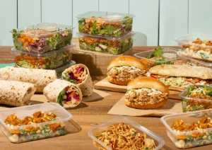 An assortment of pre-packaged meals, including salads, wraps, sandwiches, and pasta dishes.