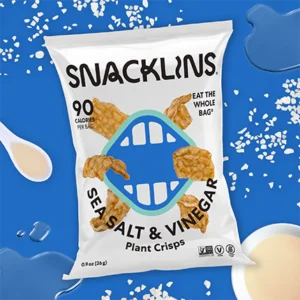 SNACKLINS Sea Salt & Vinegar Plant Crisps bag on blue backdrop.