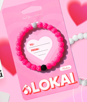 A pink bracelet featuring 'To From' and 'Lokai' written