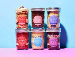 Assorted Wicked Good Cupcakes in jars with vibrant labels.